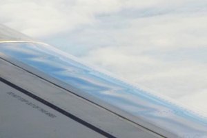 pll lot embraer jet clouds reflecting in slats.JPG