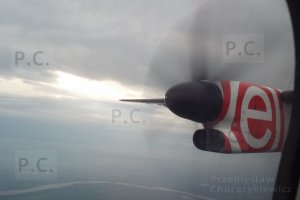 słońce przebijające się przez chmury w locie Bombardierem